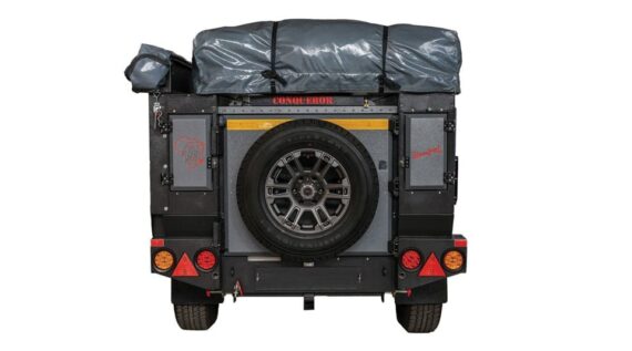 Rear view of the Conqueror Compact Platinum Edition trailer with rooftop tent and awning.