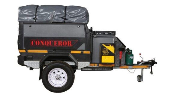 Left side view of the Conqueror Compact Platinum Edition trailer with fuel canister, gas bottles, and axe.