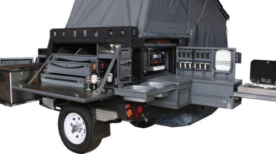 Narrow view of the fully set up Conqueror Compact Platinum Edition trailer with rooftop tent, fridge, storage space, and kitchenette.
